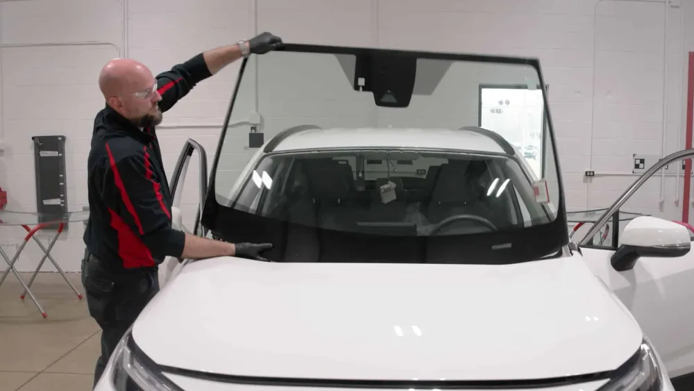 Action Glass technician setting a new windshield on an SUV